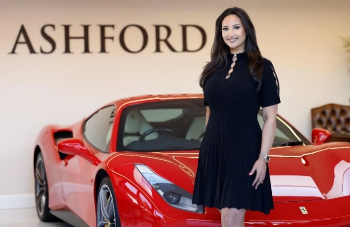 Nadia Adan stands by an expensive, red sports car