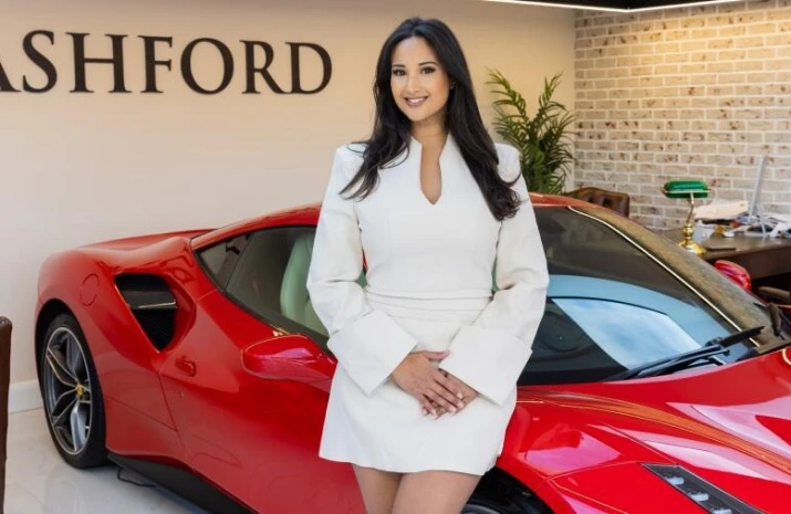 Nadia Adan stands by an expensive, red sports car